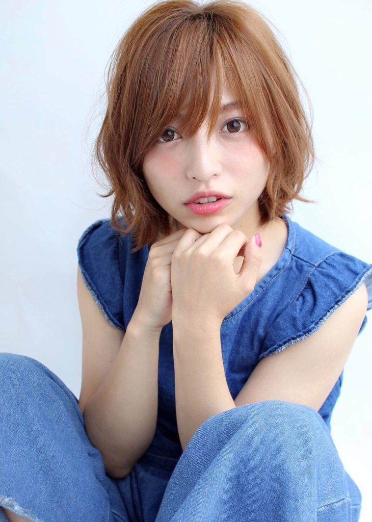 自然なブラウン色のボブスタイルが少し伸び女性らしさが際立つ女性