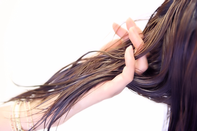 女性の髪にトリートメントを染み込ませている様子
