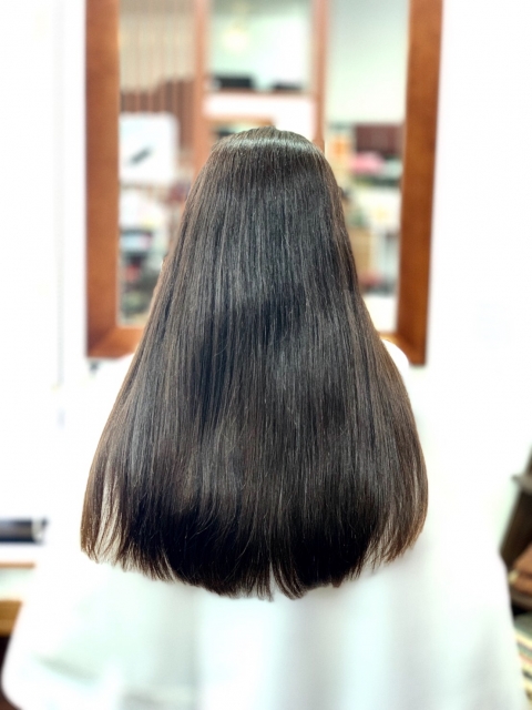 サロンのヘアケア施術で美しい髪となった女性の後ろ姿