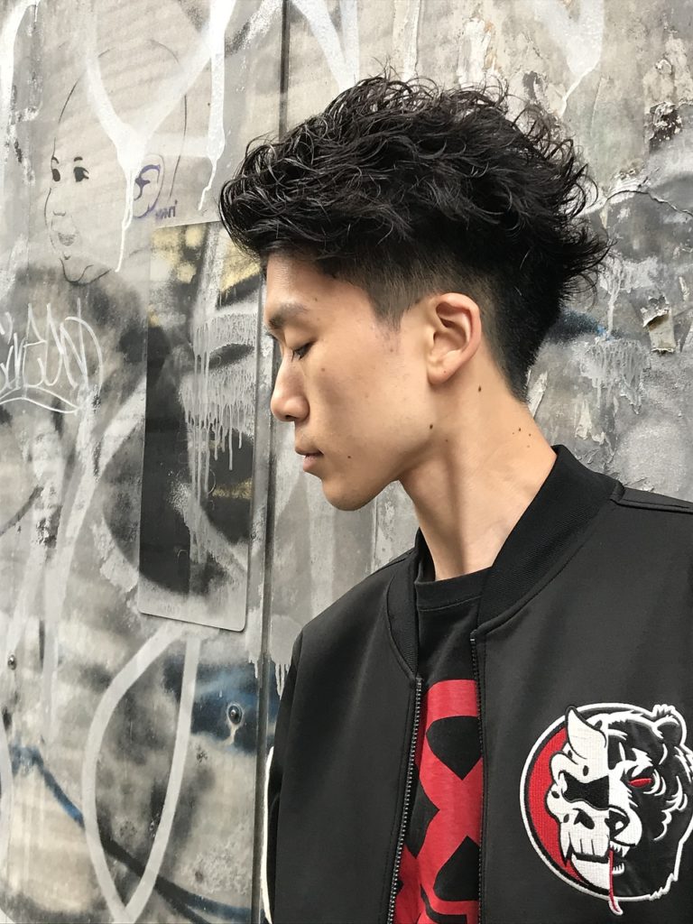パーマと刈り上げを巧みにスタイルしている自由業風男子