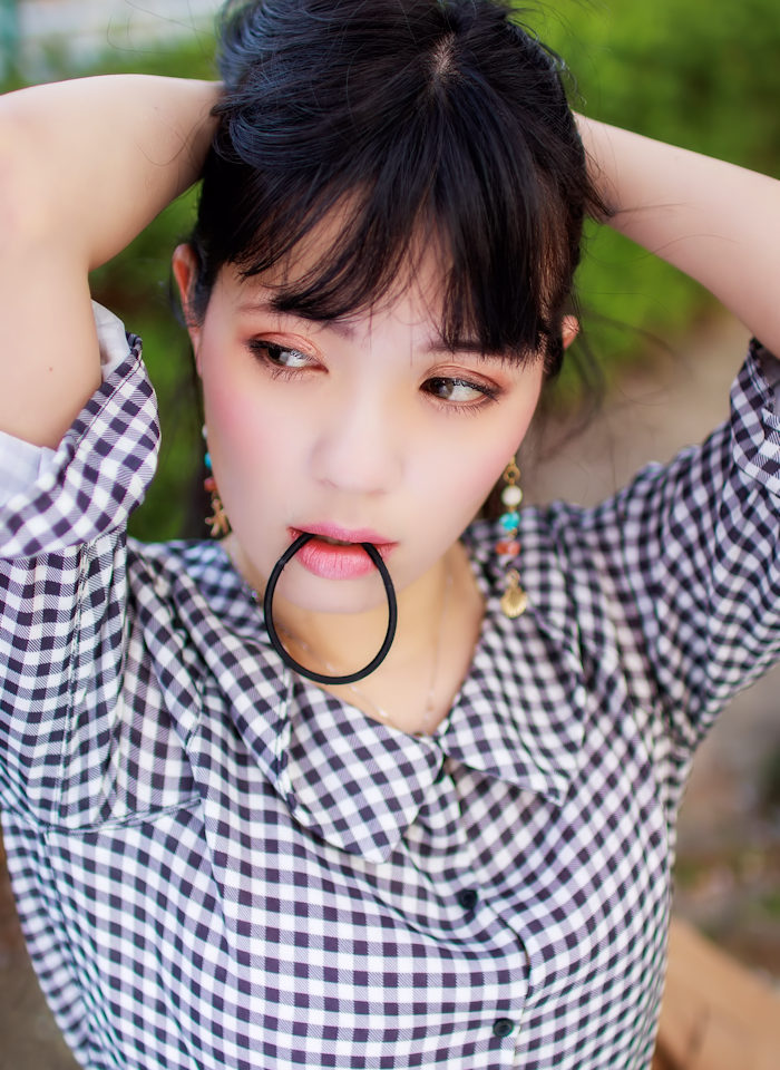 髪をヘアゴムで結ぼうとしている若い女性