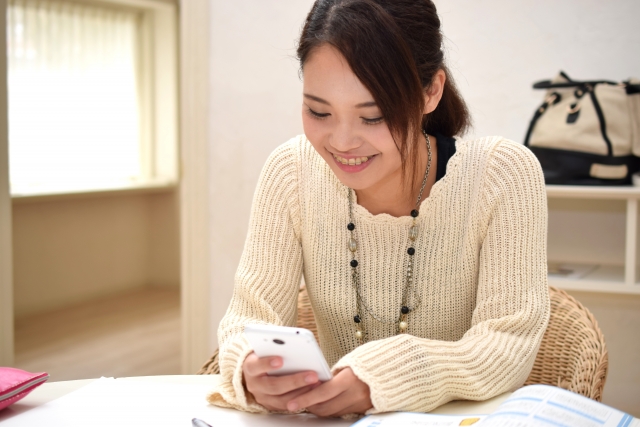 スマートフォンを操作する女性の写真