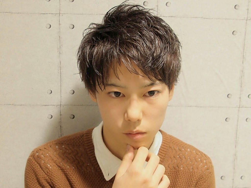 茶色の薄地のセーターを着たエアリー感あるショートヘア男子