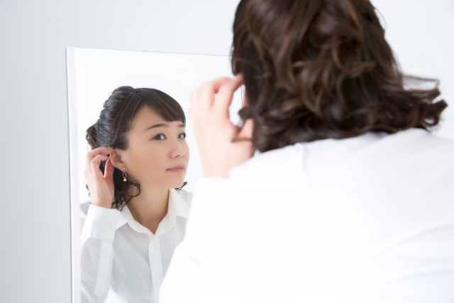 髪型に悩んで鏡を見る女性