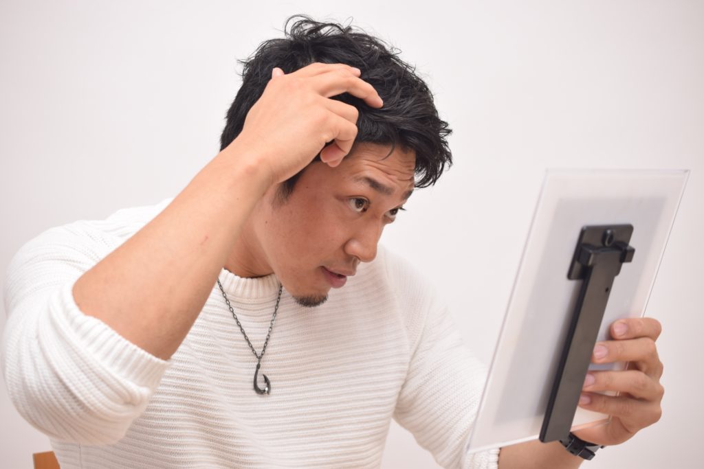 髪型をセットする男性の写真