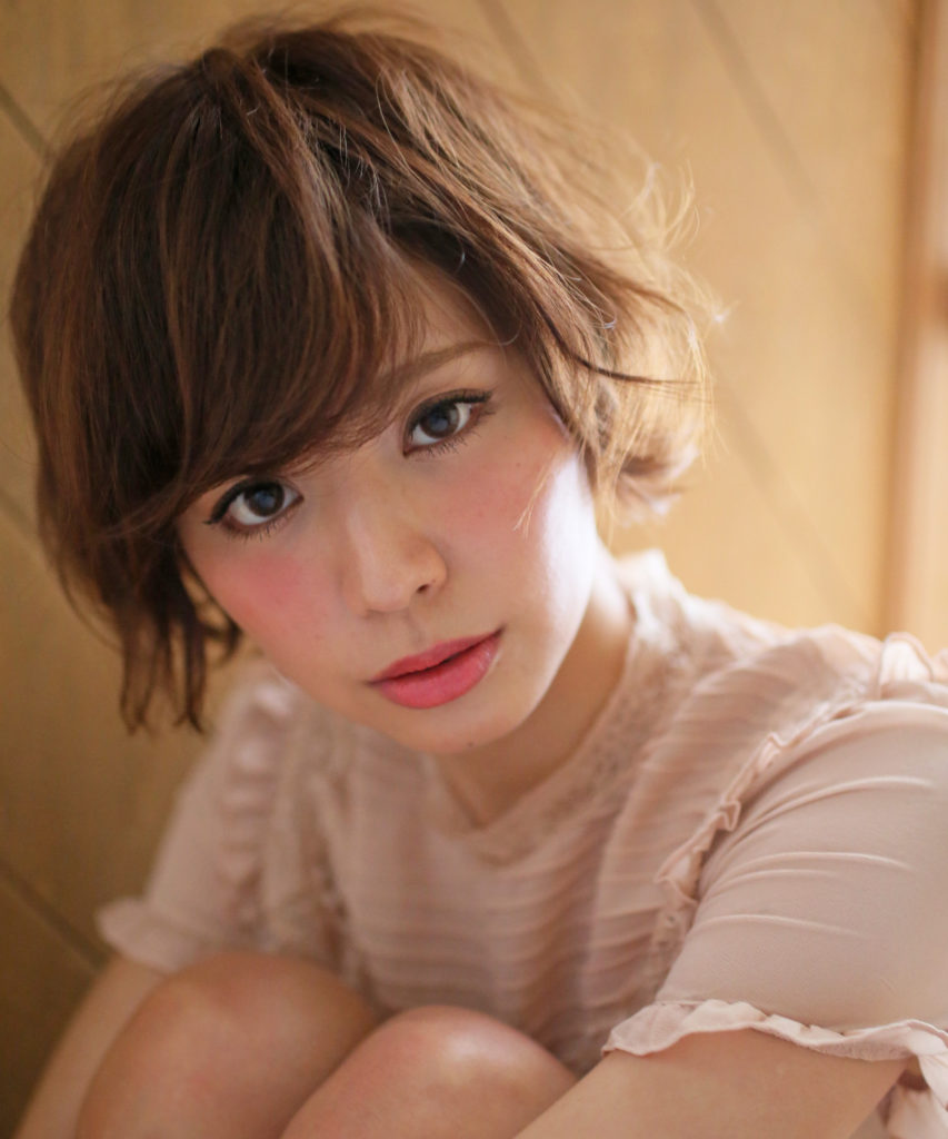 ふんわりパーマをかけたショートカットのかわいらしい女性