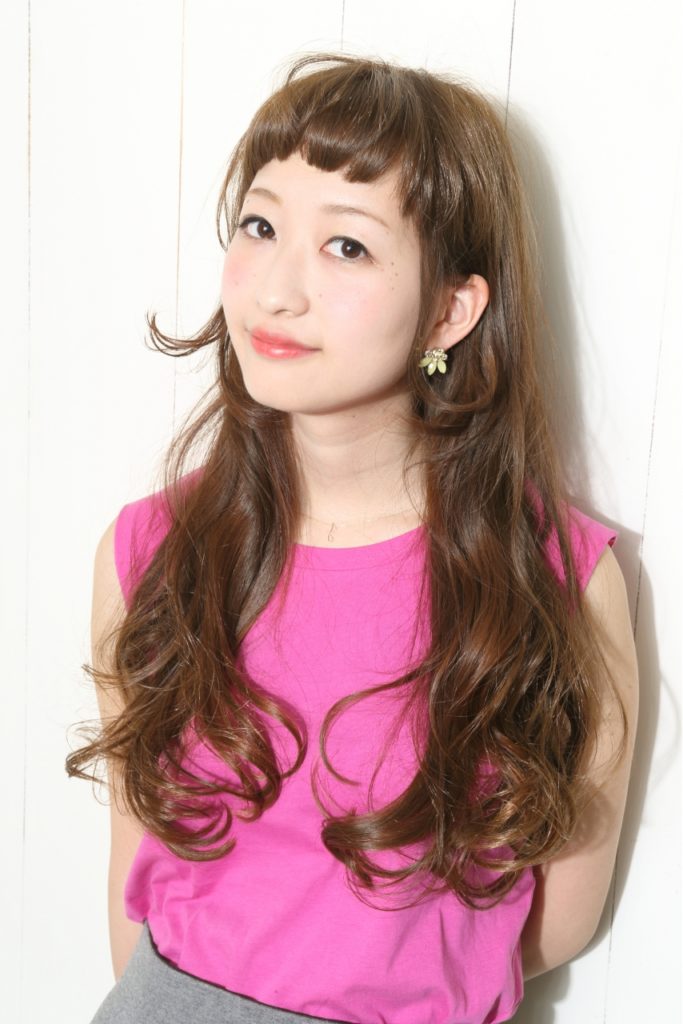 ロングのウェーブヘアで前髪をショートにした女性