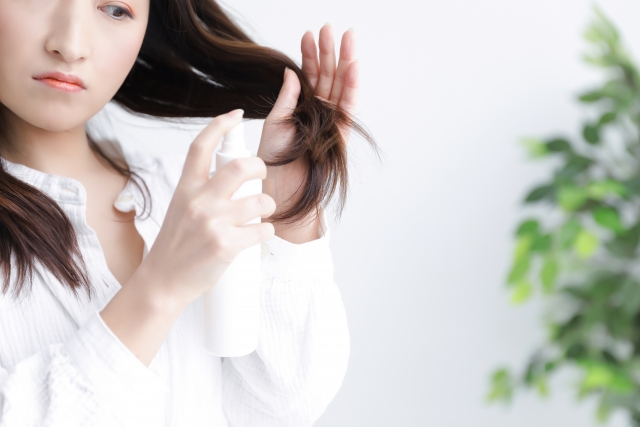 毛先を見る女性の写真