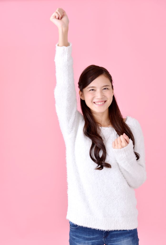 こぶしを振り上げる女性の写真