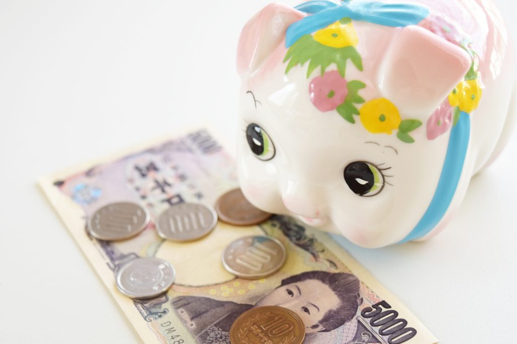 お金とブタの貯金箱の写真
