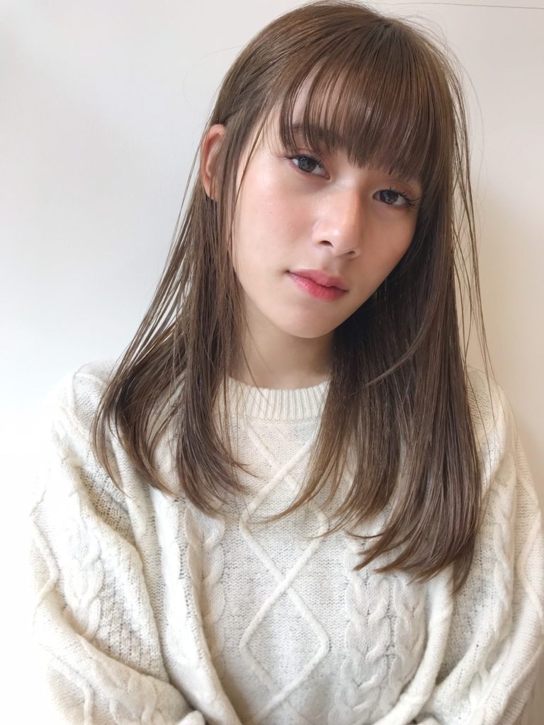 白いセーターを着たサラサラロングヘアの女性の写真