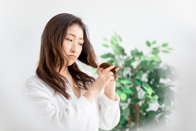 髪に悩む女性の写真