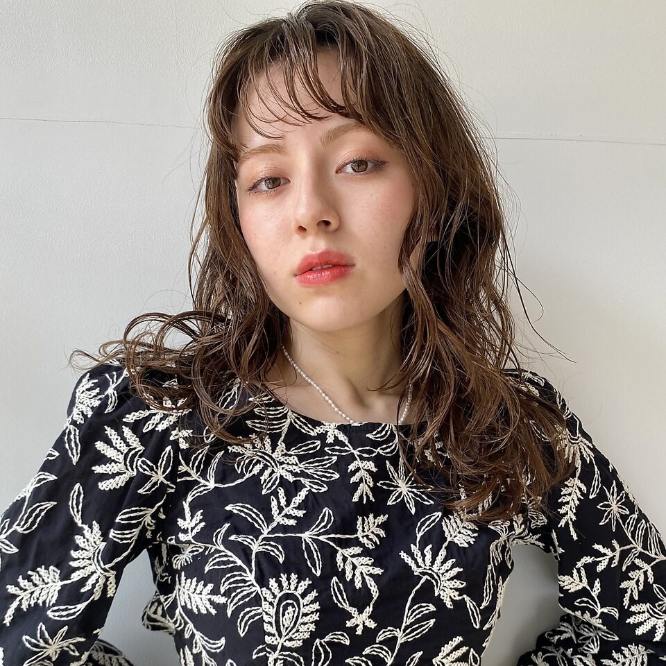 パーマをかけたロングヘアの女性の写真
