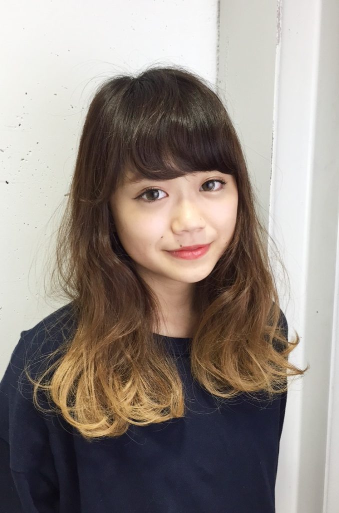 根元から毛先にいくにつれてだんだん明るく染まったヘアカラーの女性の写真