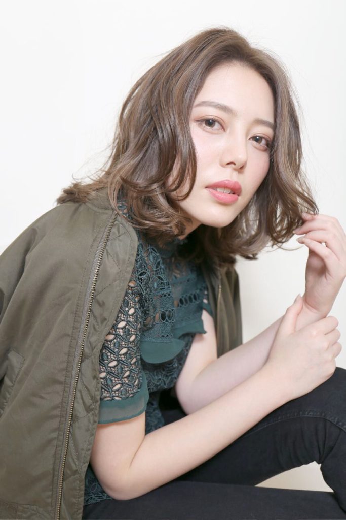 センター分けの長め前髪が大人っぽい雰囲気のミディアムヘアの女性の写真