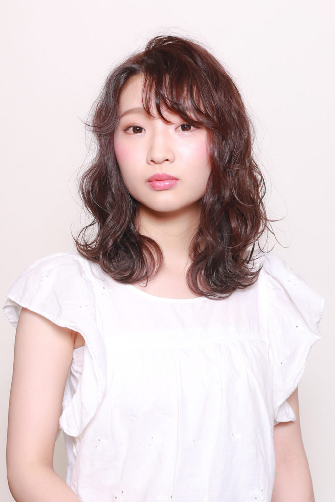 薄めの前髪がオシャレなミックスパーマヘアの女性の写真