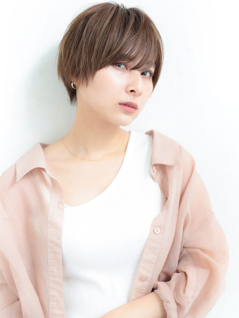 目にちょうどかかる前髪がシャープさをプラスする、ショートヘアの女性の写真