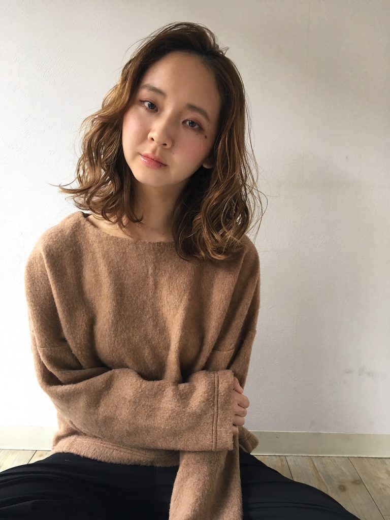 かき上げつつも斜めに流した前髪のシルエットがキレイな、ロブヘアの女性の写真