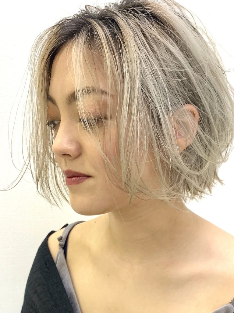 根元付近から明るめベージュアッシュのオンブレをした女性の写真