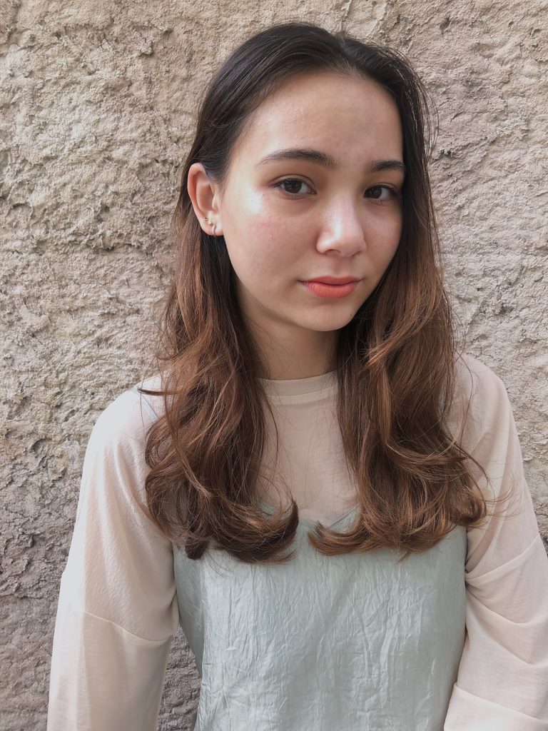 ふんわりと柔らかいキャメルブラウンのオンブレをした女性の写真