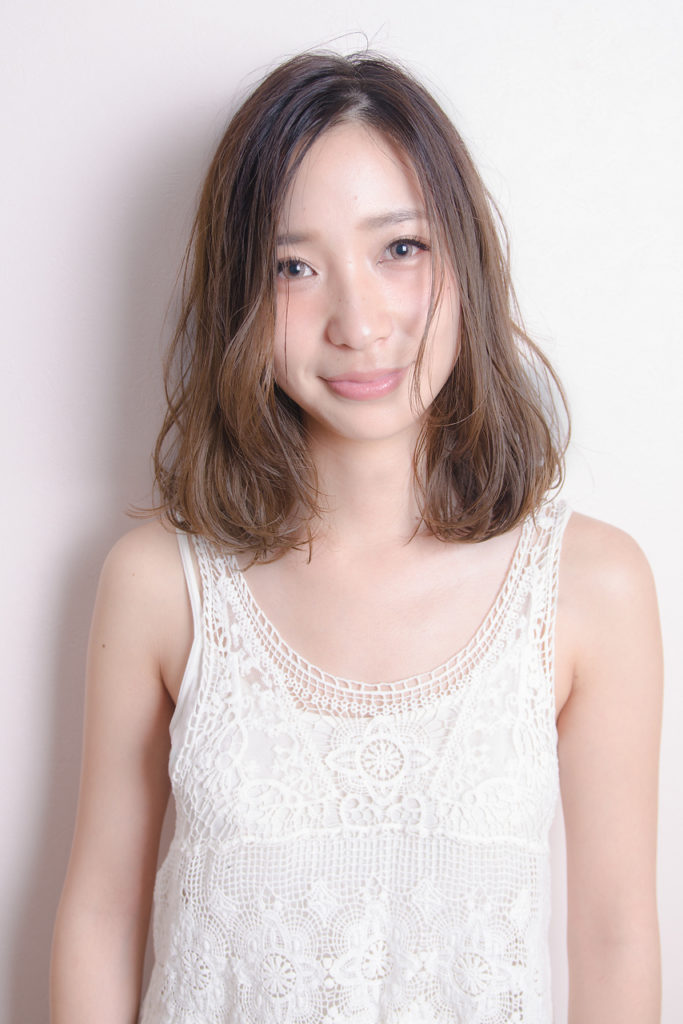 とろんとしたカールがかわいいロブヘアの女性の写真