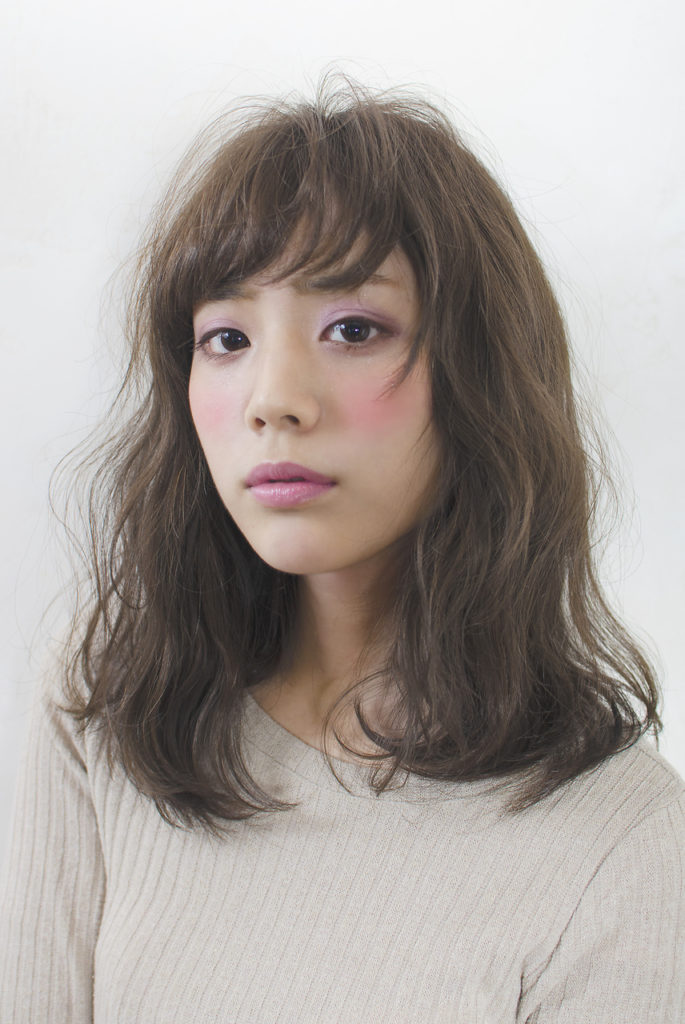 くせ毛風パーマがよく似合うミディアムヘアの女性の写真