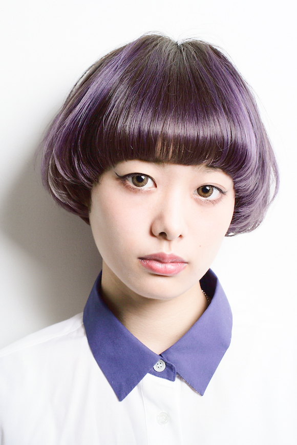 個性的なラベンダーカラーのハイライトが入ったマッシュヘアの女性の写真
