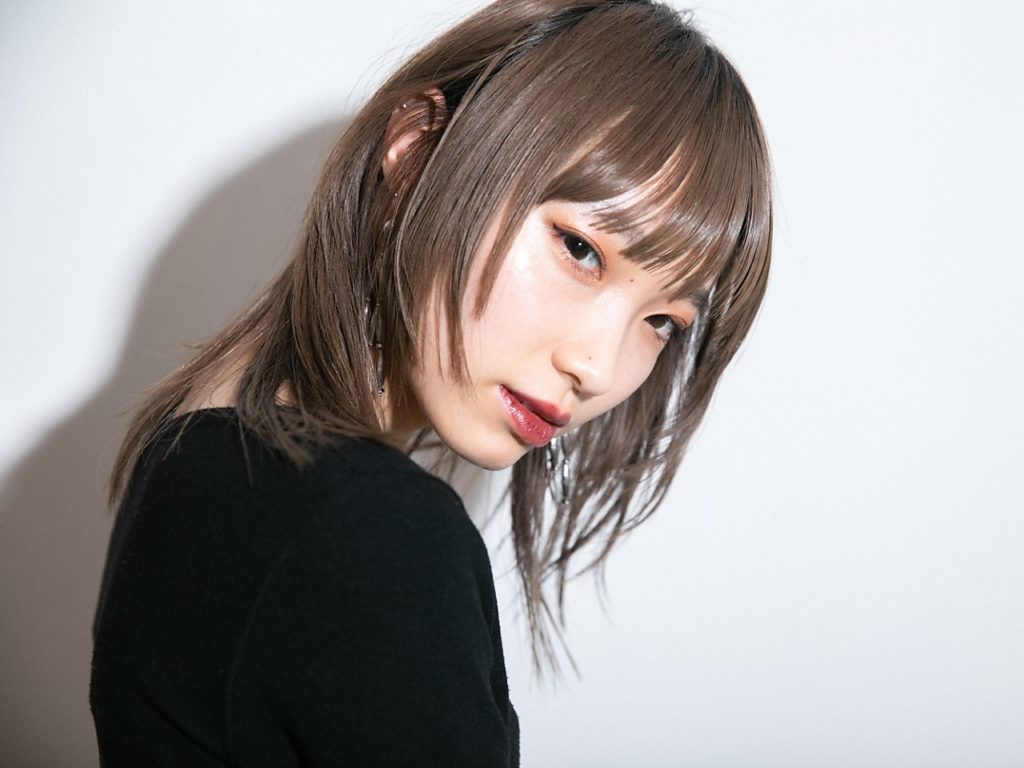 ツヤツヤのブラウンカラーをしたミディアムヘアの女性の写真
