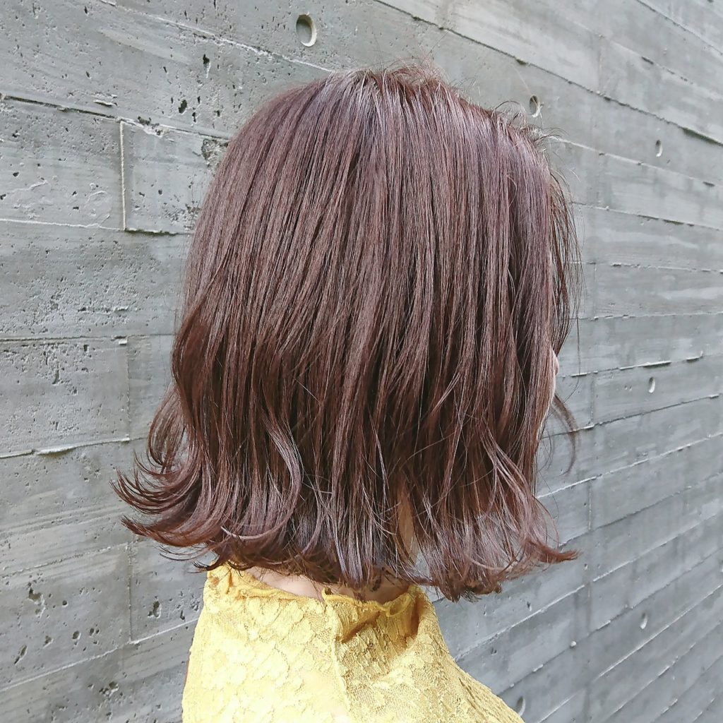 発色の良いパープルカラーをした外はねヘアの女性の写真