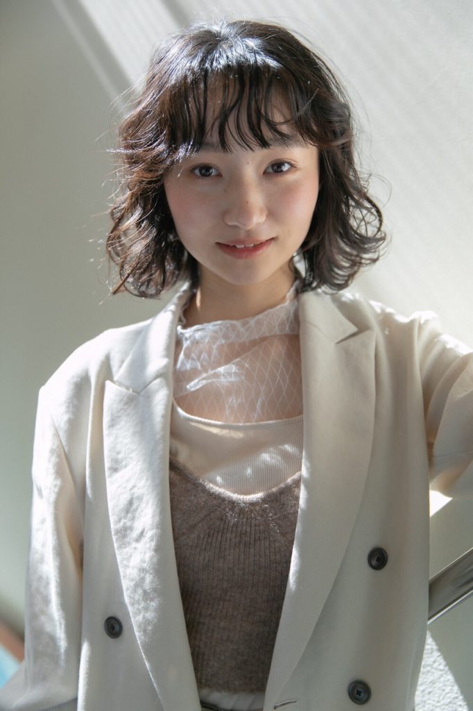 ふんわりしなやかな髪に見えるラベンダーカラーの女性の写真