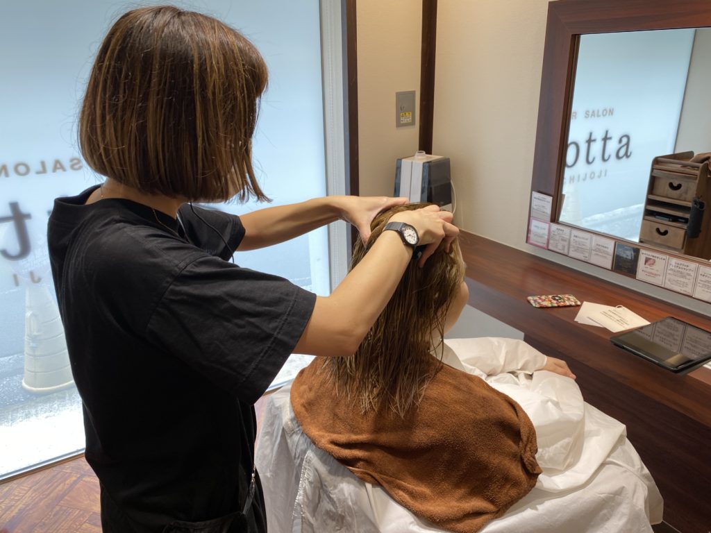 美容師が頭をマッサージしている写真