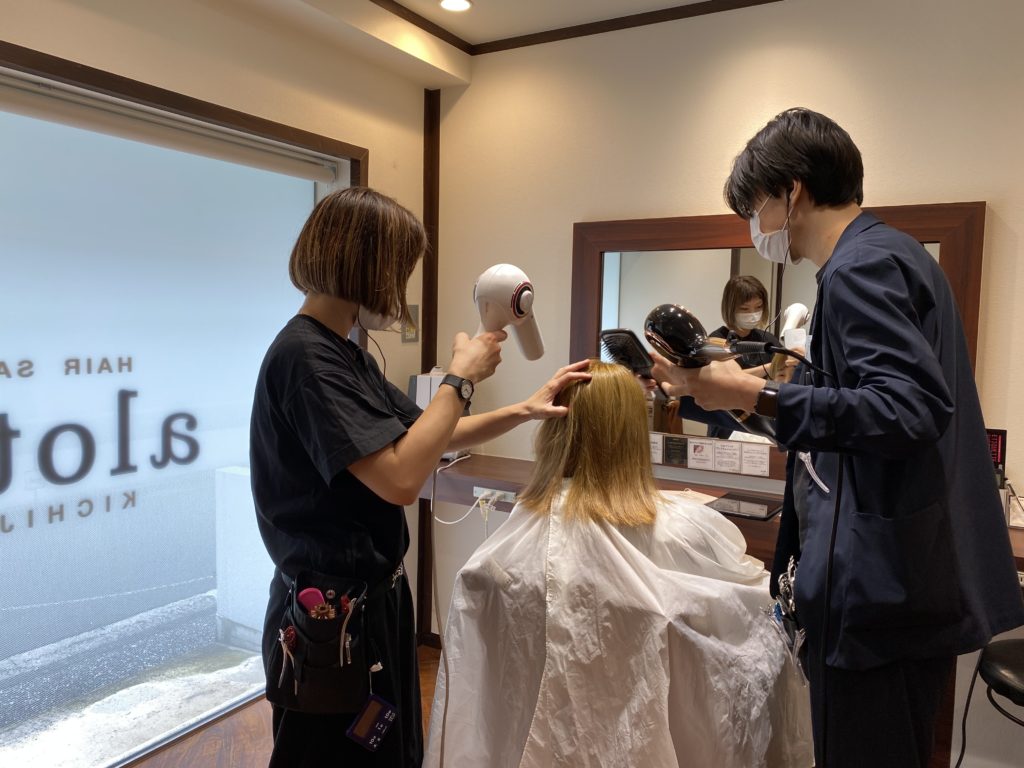 2人の美容師にドライヤーをかけてもらっている写真