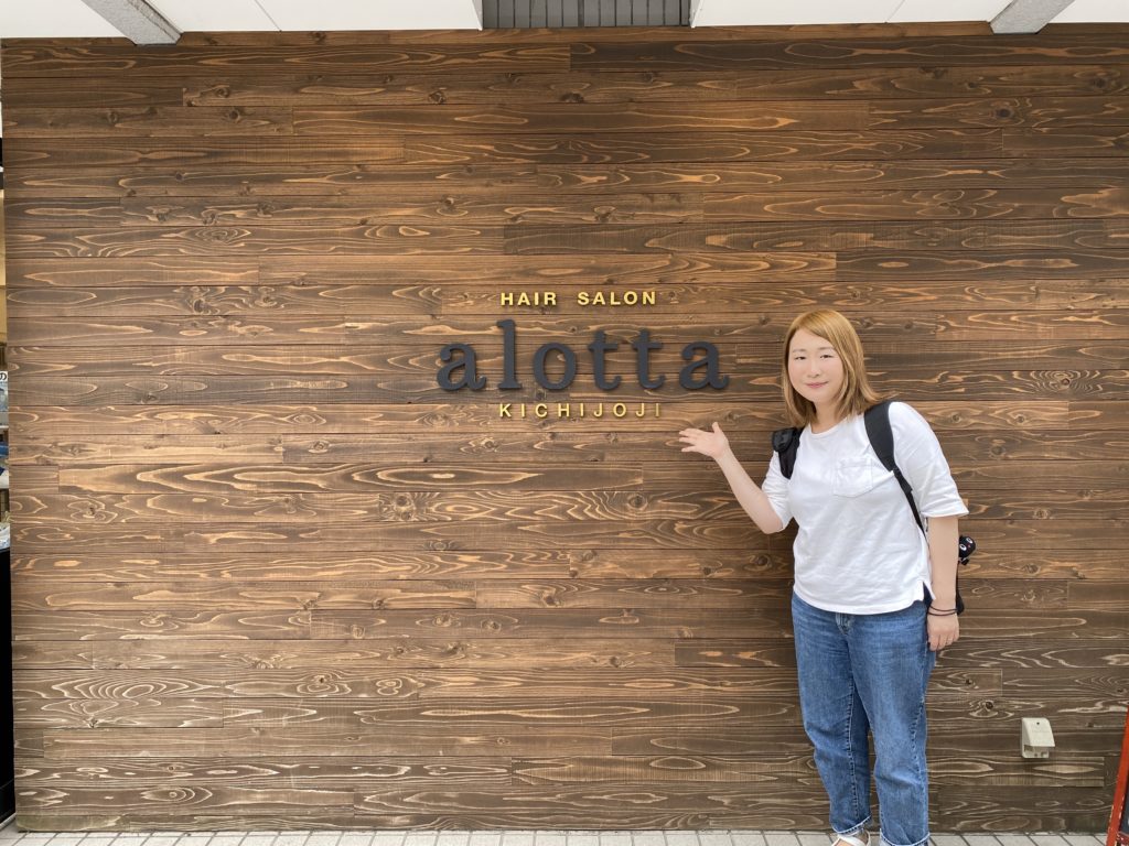 アロッタの看板の前に立つ女性の写真