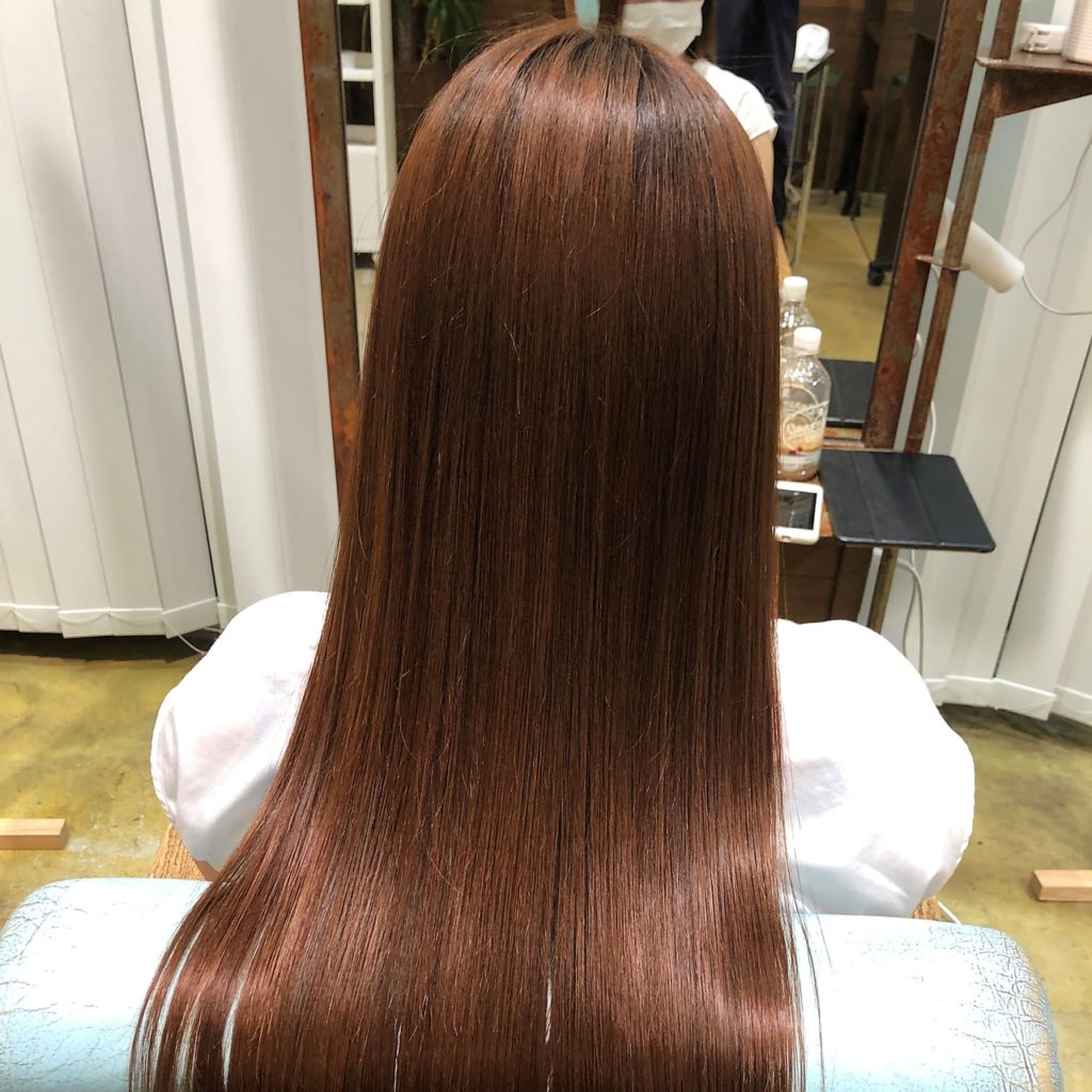 ツヤツヤの毛先を触る美容師の手元の写真