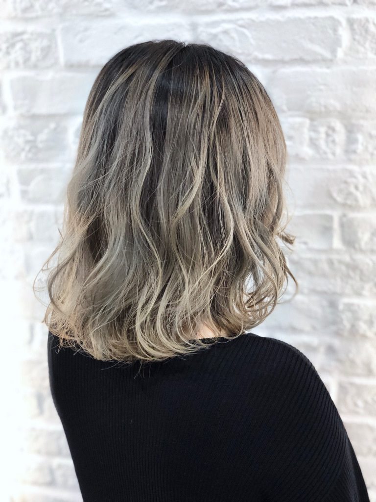 くっきりとしたベージュのバレイヤージュカラーをしたミディアムヘアの女性の写真