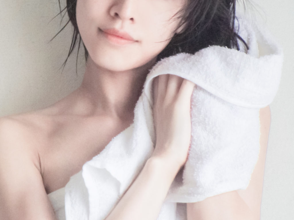 濡れた髪をタオルドライする女性の写真