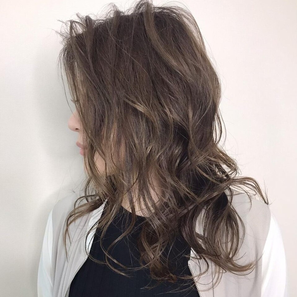 落ち着いたグレージュのバレイヤージュカラーをしたロングヘアの女性の写真