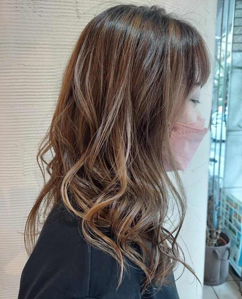 くっきりとしたベージュのバレイヤージュカラーをしたミディアムヘアの女性の写真