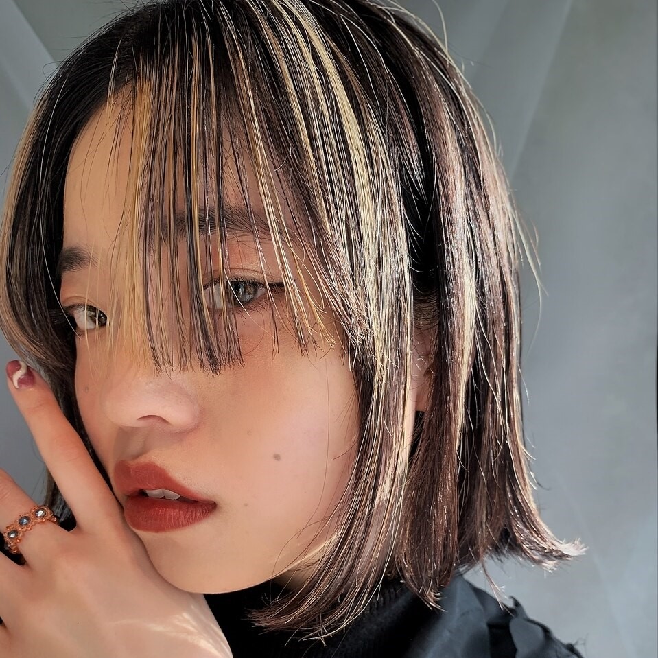 明るめベージュアッシュのバレイヤージュカラーをしたロングヘアの女性の写真