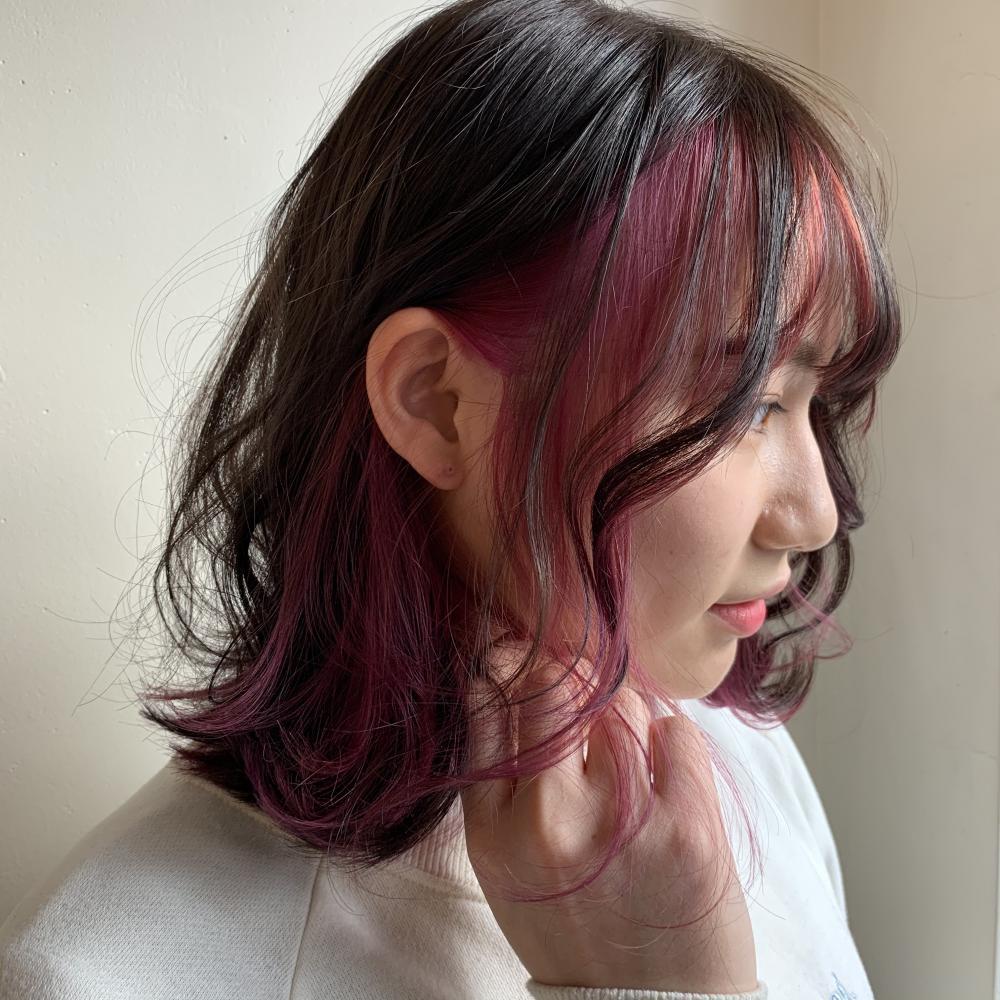 顔周りを明るめピンクのフェイスフレーミングカラーに染めた女性の写真