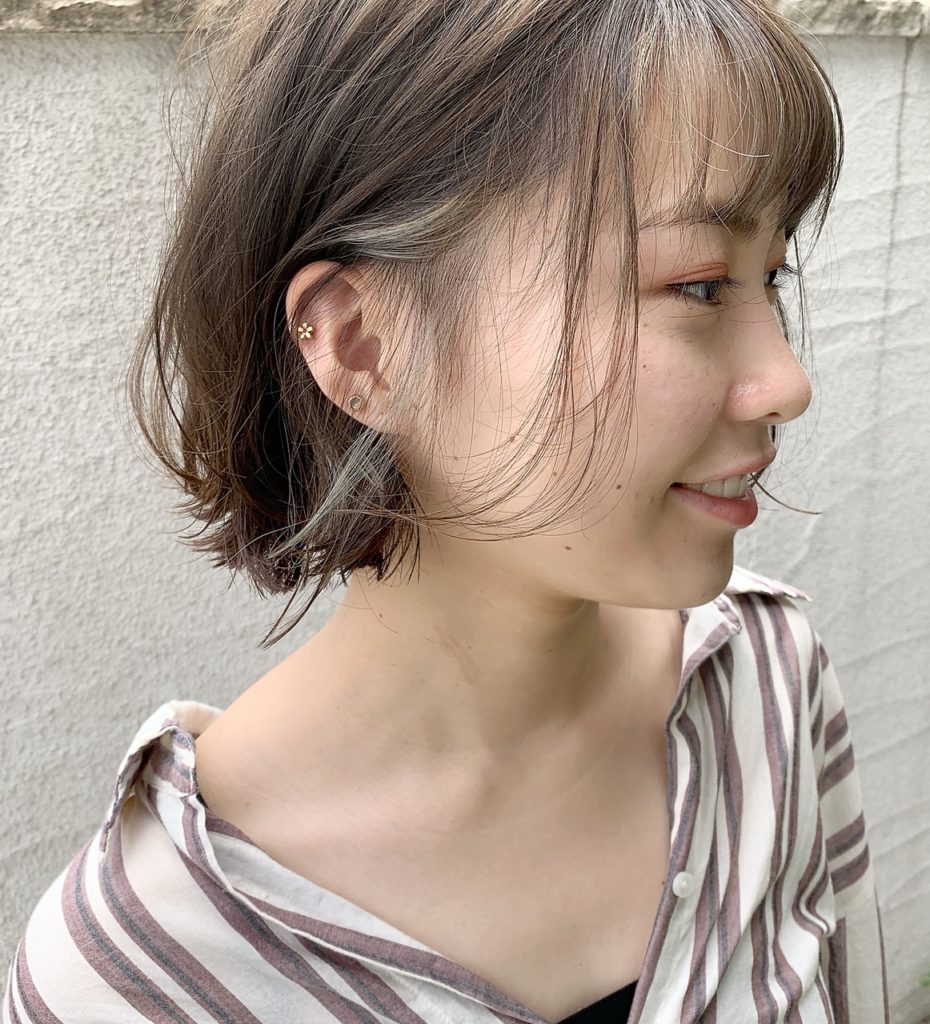 眉上前髪と顔周りを細めのフェイスフレーミングカラーに染めた女性の写真