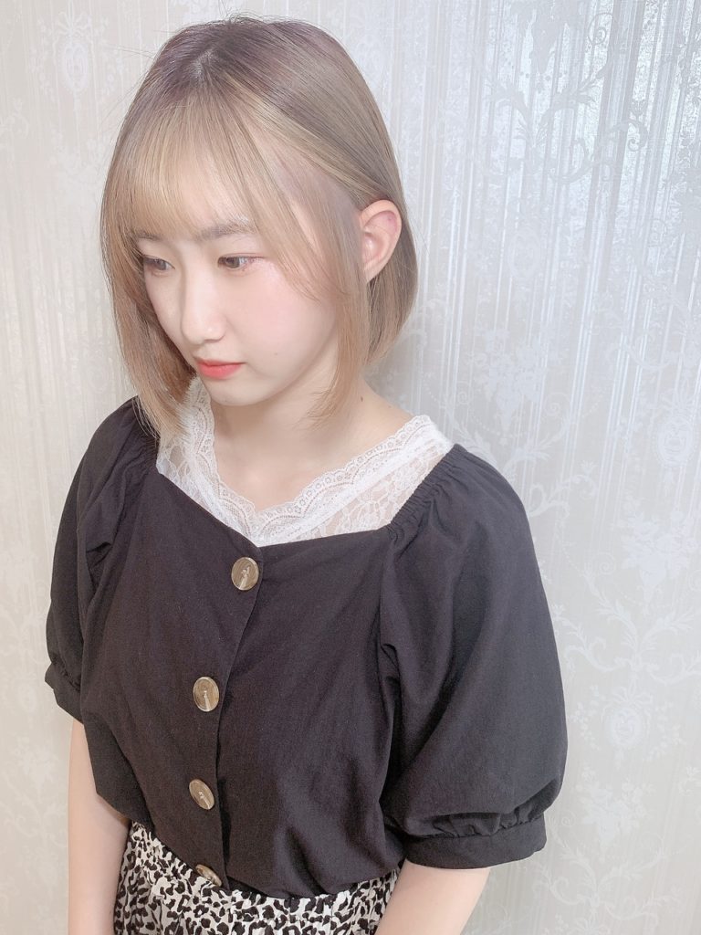 眉上前髪と顔周りをグレージュのフェイスフレーミングカラーに染めた女性の写真