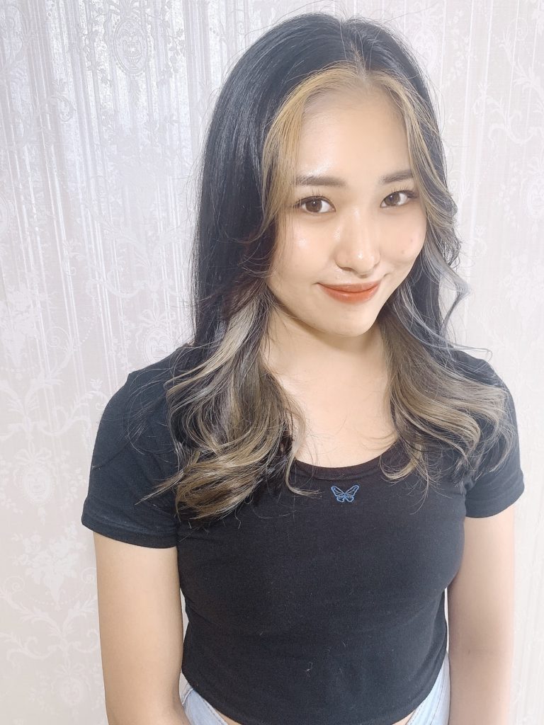 長め前髪と顔周りをゴールドのフェイスフレーミングカラーに染めた女性の写真
