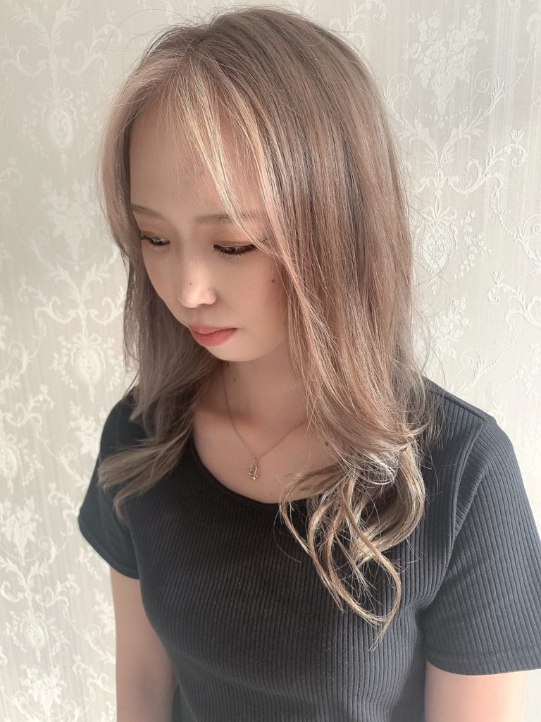 長め前髪に細いゴールドのフェイスフレーミングカラーを入れた女性の写真