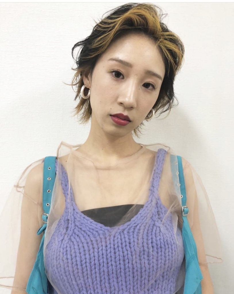 かきあげ前髪をゴールドのフェイスフレーミングカラーに染めた女性の写真