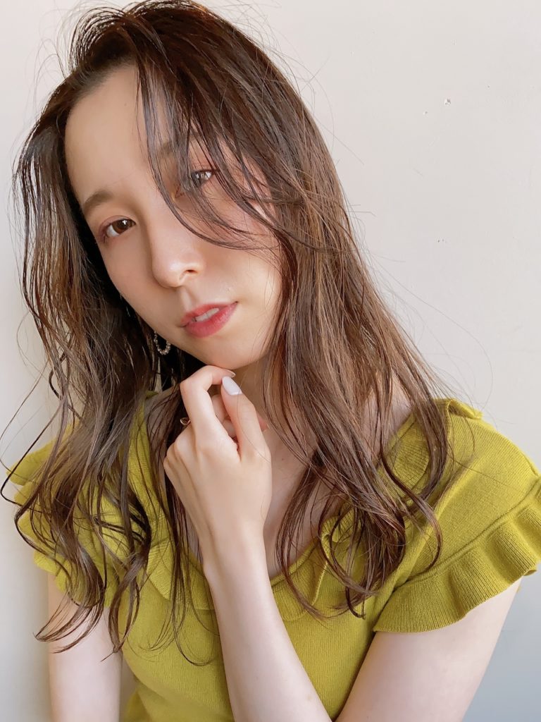 ゆるいウェーブと頬の高さの前髪がロマンチックな印象のロングヘアの女性の写真