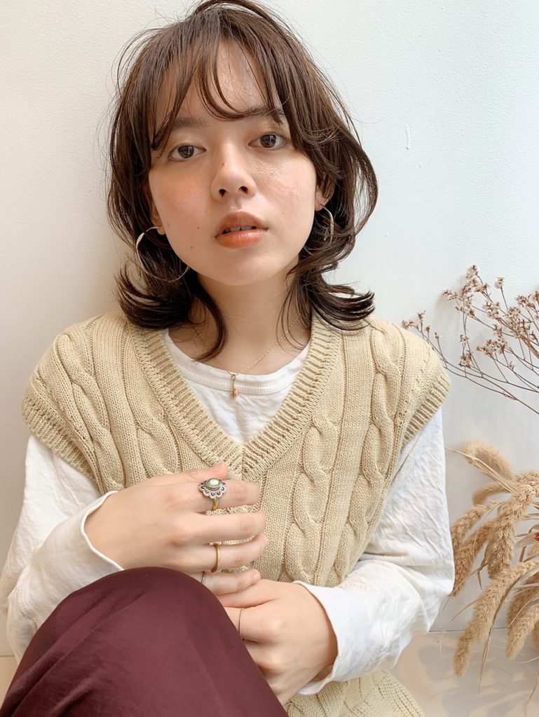 くびれたレイヤーの入った軽いミディアムヘアの女性の写真