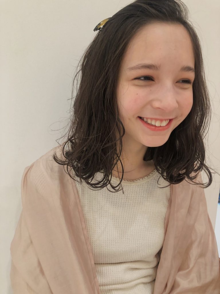 大きめピンでポンパドールにヘアアレンジした女性の写真