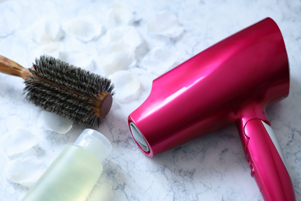 大理石の上に置かれたヘアドライヤーとブラシの写真
