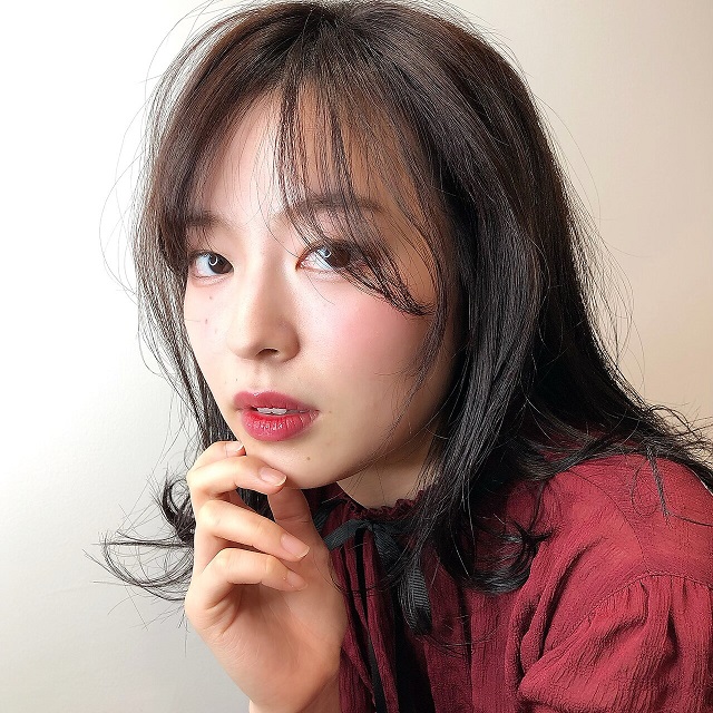 手に顎を置いた女性の写真